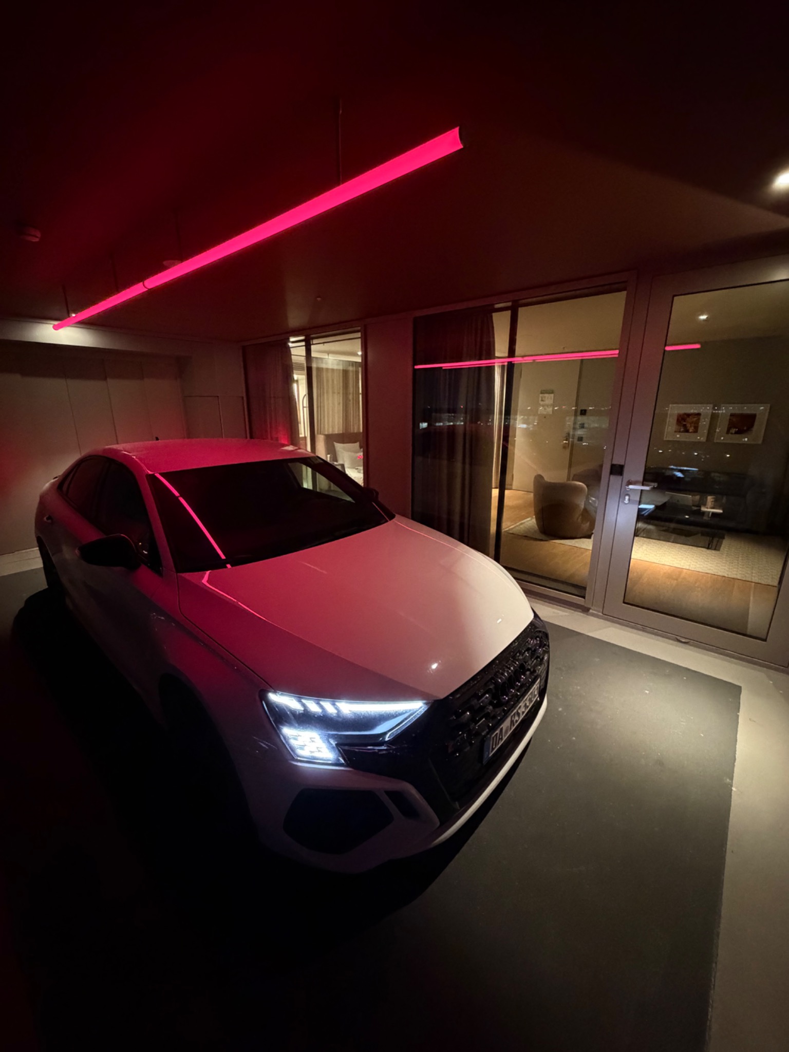 Audi vor einem modernen Hotel bei Nacht